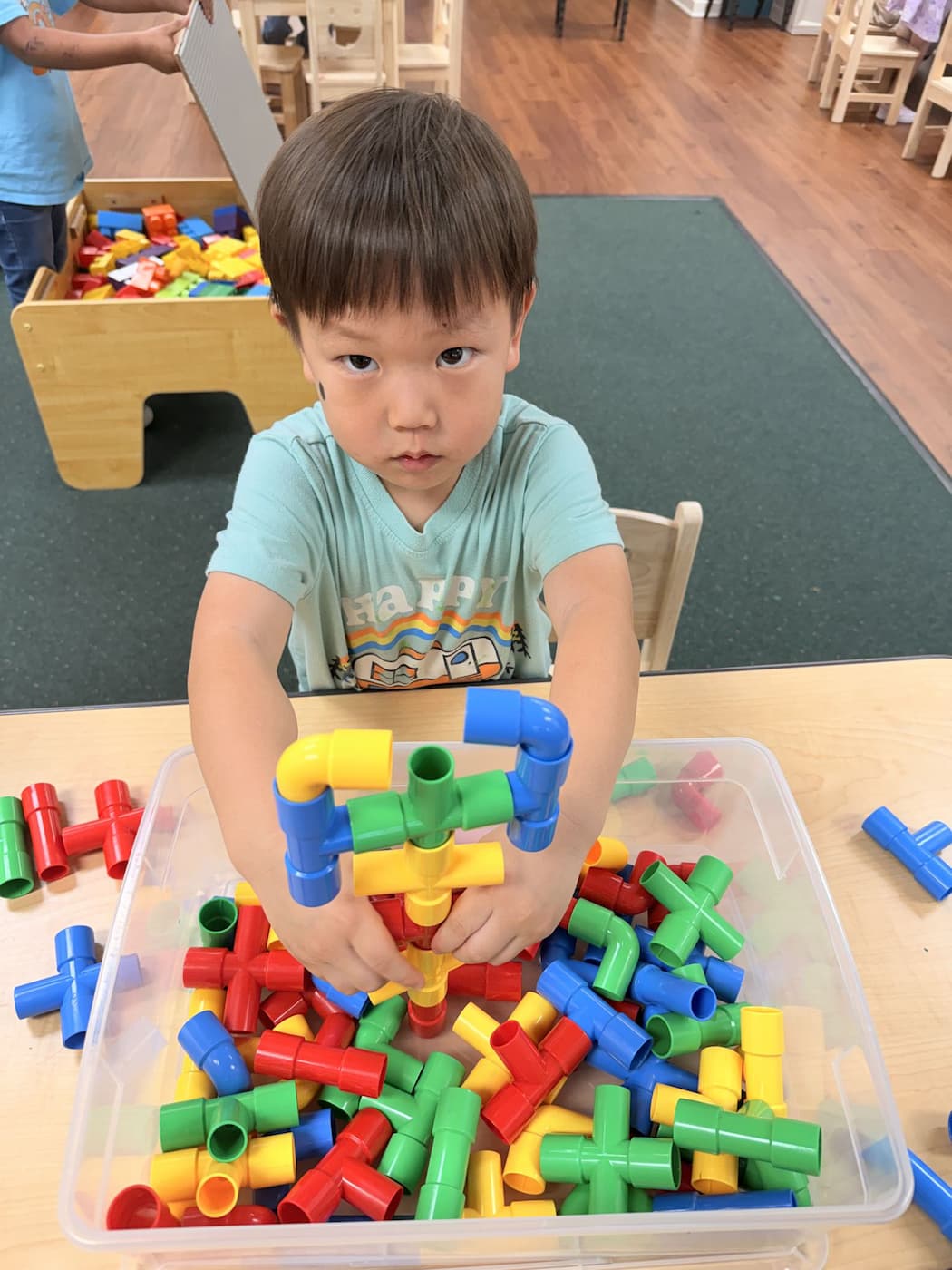 Child building with hands-on materials in Palm Grove Montessori classroom in Plano TX
